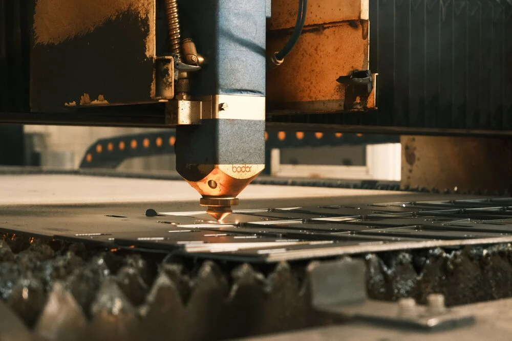 CNC laser cutting machine precisely cutting sheet metal for custom metal fabrication.