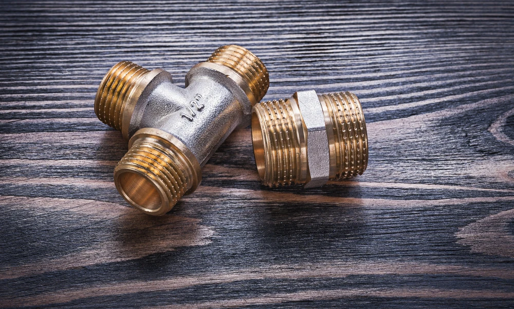 metal-plumbing-components-on-textured-wooden-surfa